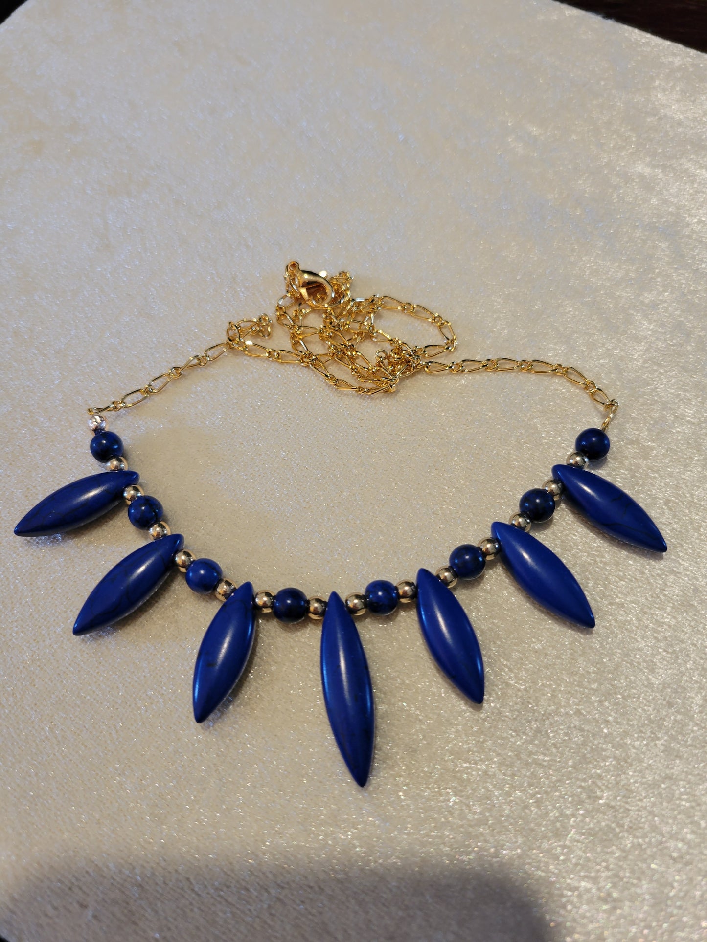 Gold tone necklace with blue glass spikes, 20 inches