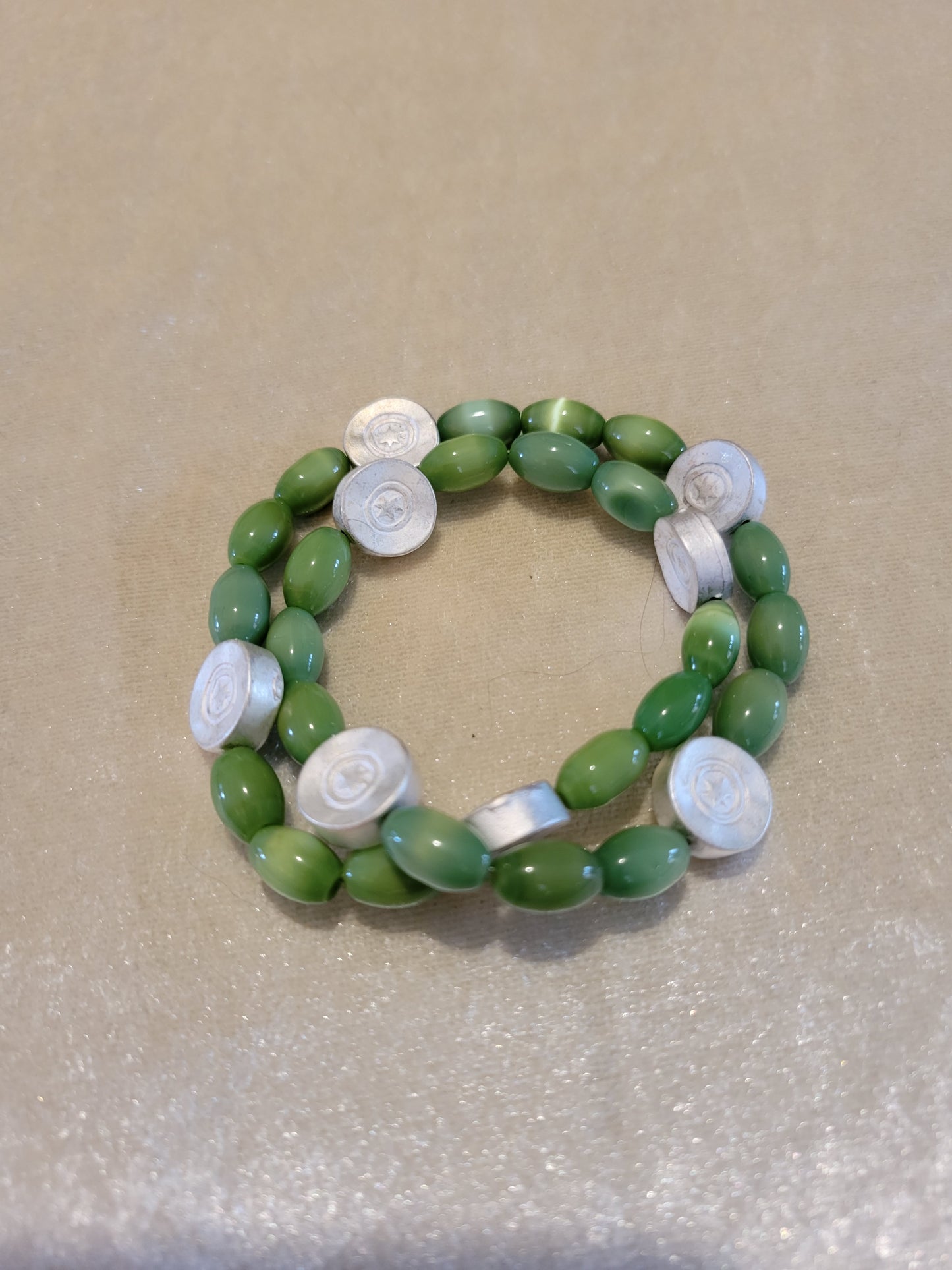 Green cats' eye glass with silver tone disk bracelet